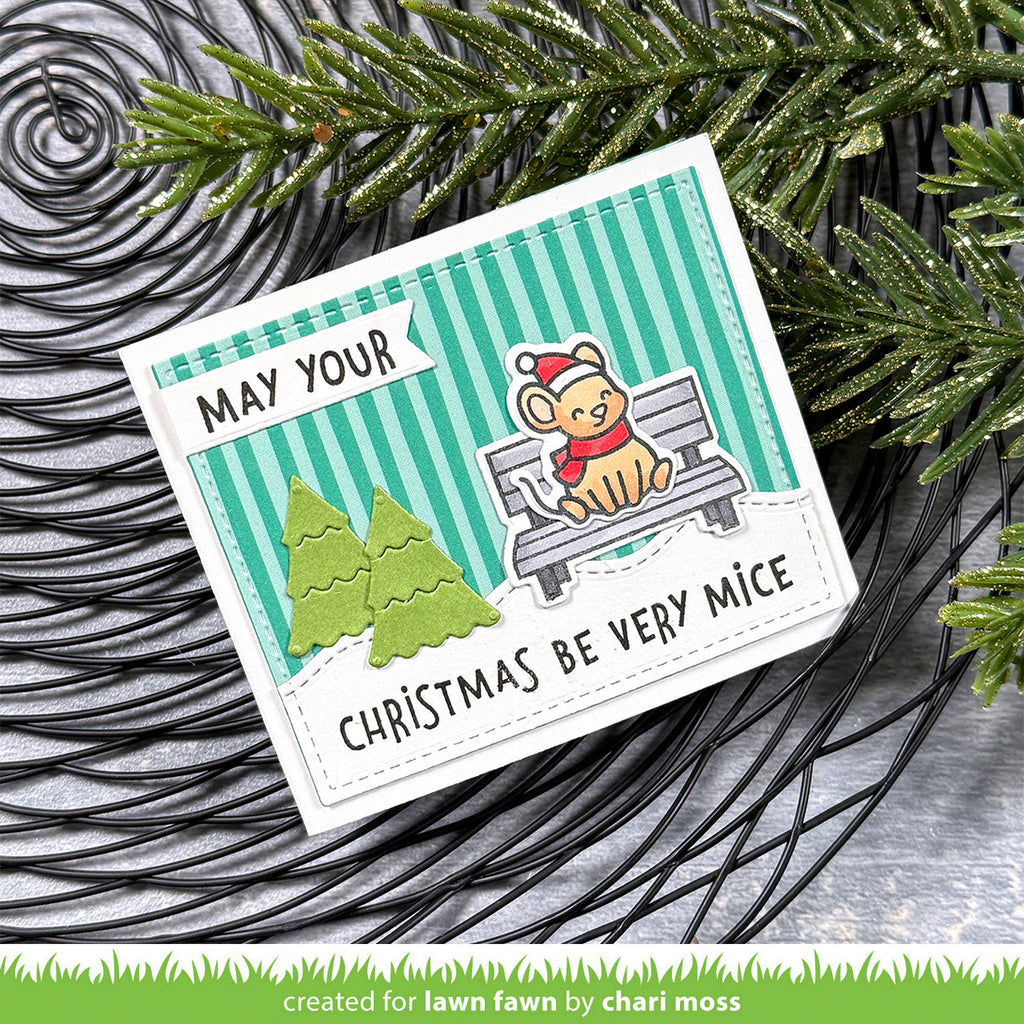 Christmas-themed card with a mouse on a bench and festive text, surrounded by greenery.