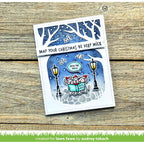 Christmas-themed card with cartoon mice and festive text on a wooden surface