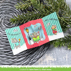 Christmas-themed card with cartoon mice and festive design, placed on a textured surface with greenery.