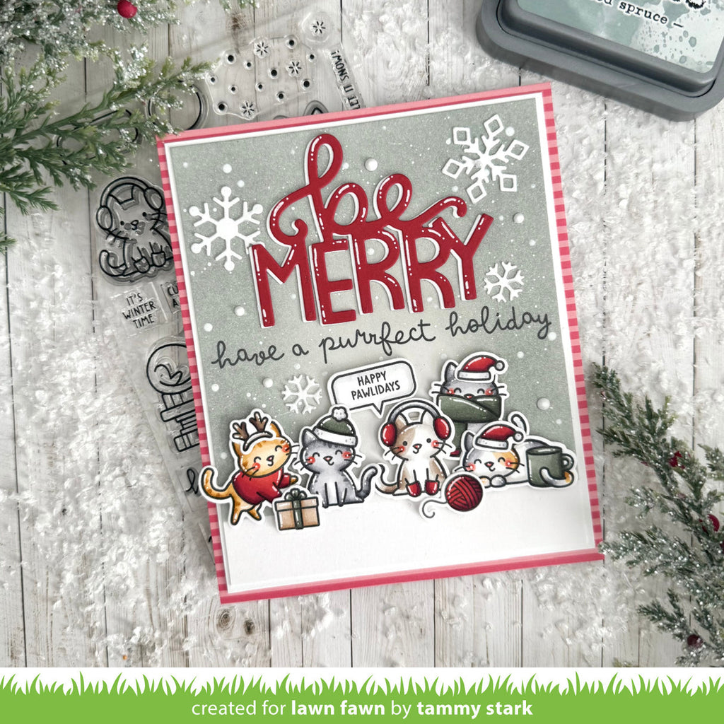Christmas card with 'Be Merry' text and cartoon animals on a wooden surface with holiday decorations.