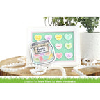 Card with a jar of candy hearts and 'Happy Heart Day' text, placed on a white surface with decorative elements.