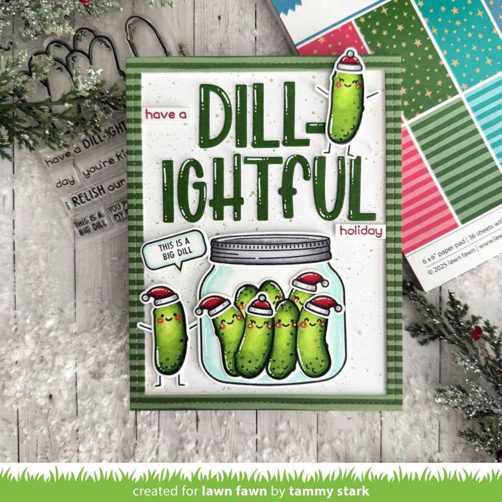 Holiday card with pickles in a jar and text 'have a DILL-IGHTFUL holiday' on a wooden surface.