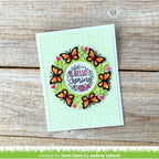 Card with butterflies and 'Hello Spring' text on a wooden surface