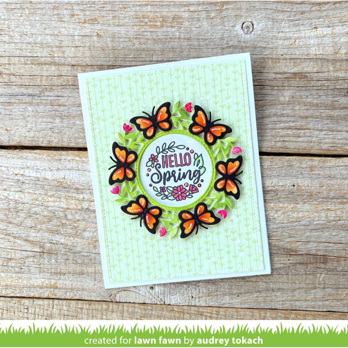 Card with butterflies and 'Hello Spring' text on a wooden surface
