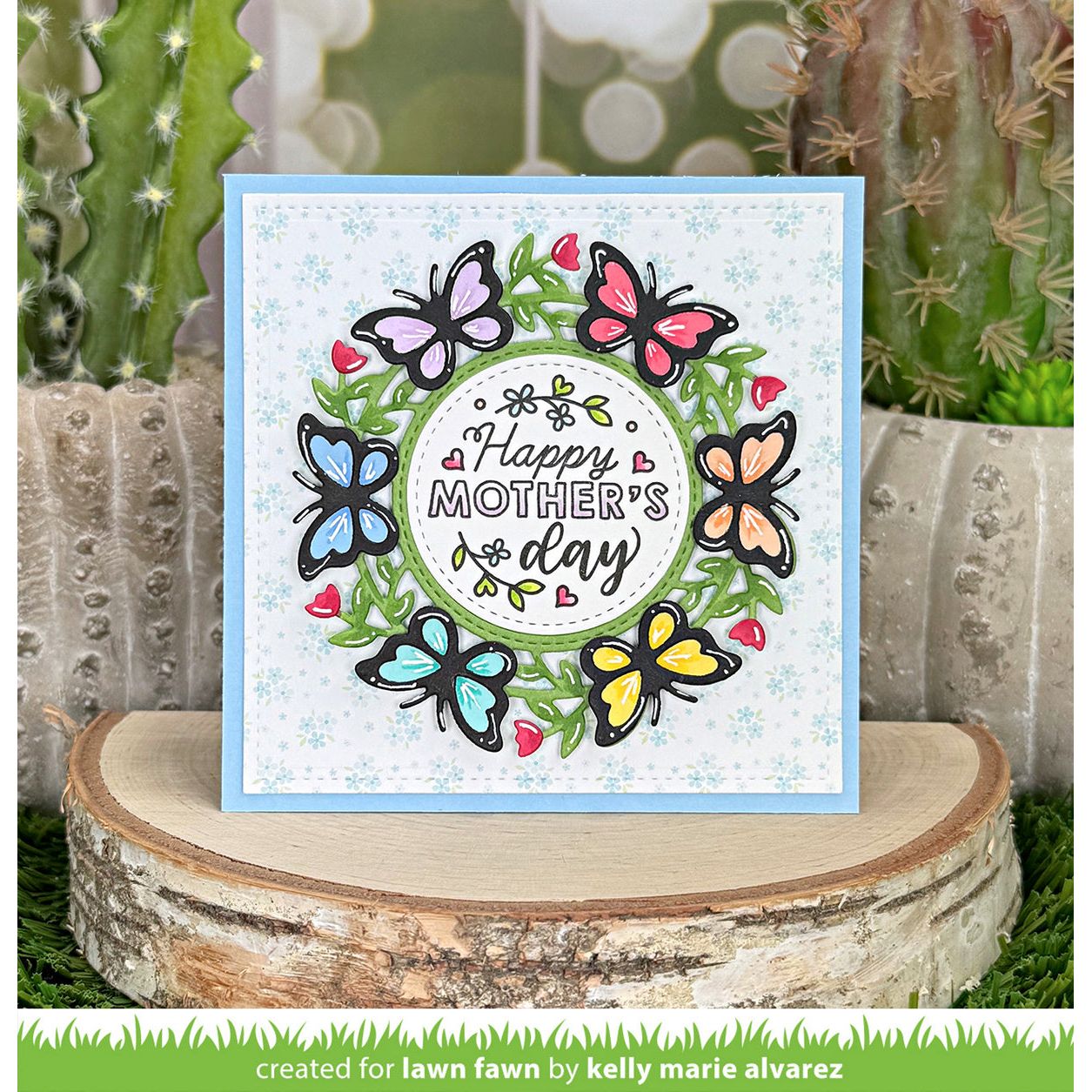Mother's Day card with colorful butterflies on a wooden block with cacti in the background