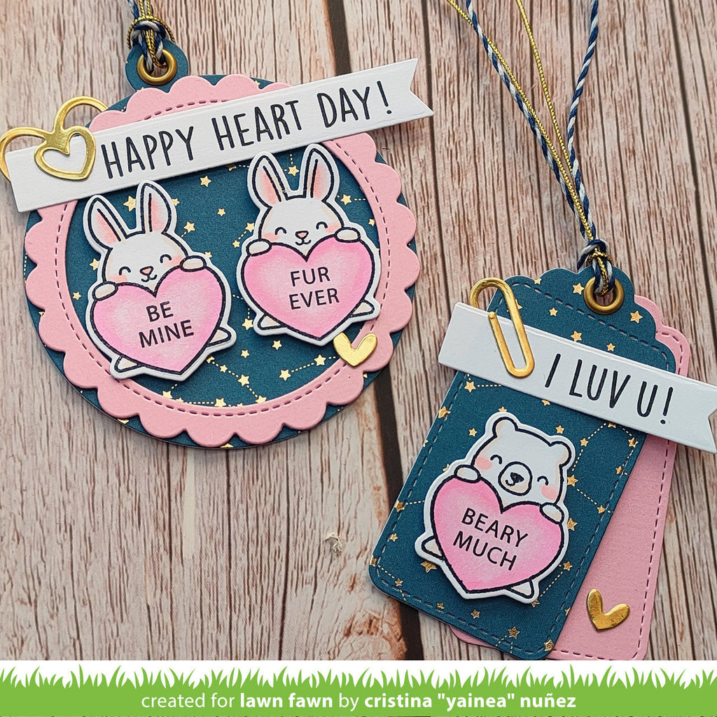 Two decorative tags with cartoon animals and heart-shaped messages on a wooden surface.