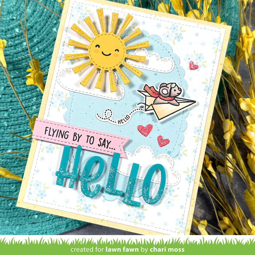 Handmade card with a sun, mouse in paper airplane and 'hello' text on a textured background