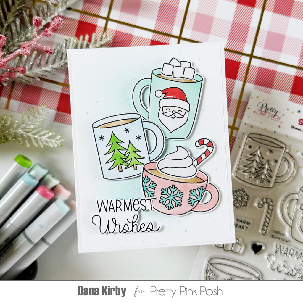 Pretty Pink Posh Warm Heart STAMPtember Exclusive Dana Kirby card with three cups of cocoa and the sentiment warmest wishes. Each cup has a different character on the front