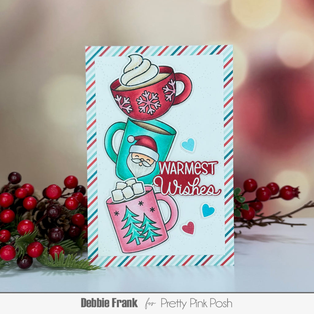 Pretty Pink Posh Warm Heart STAMPtember Exclusive Striped background card from Debbie Frank Containing the sentiment warmest wishes and three hot cocoa cups