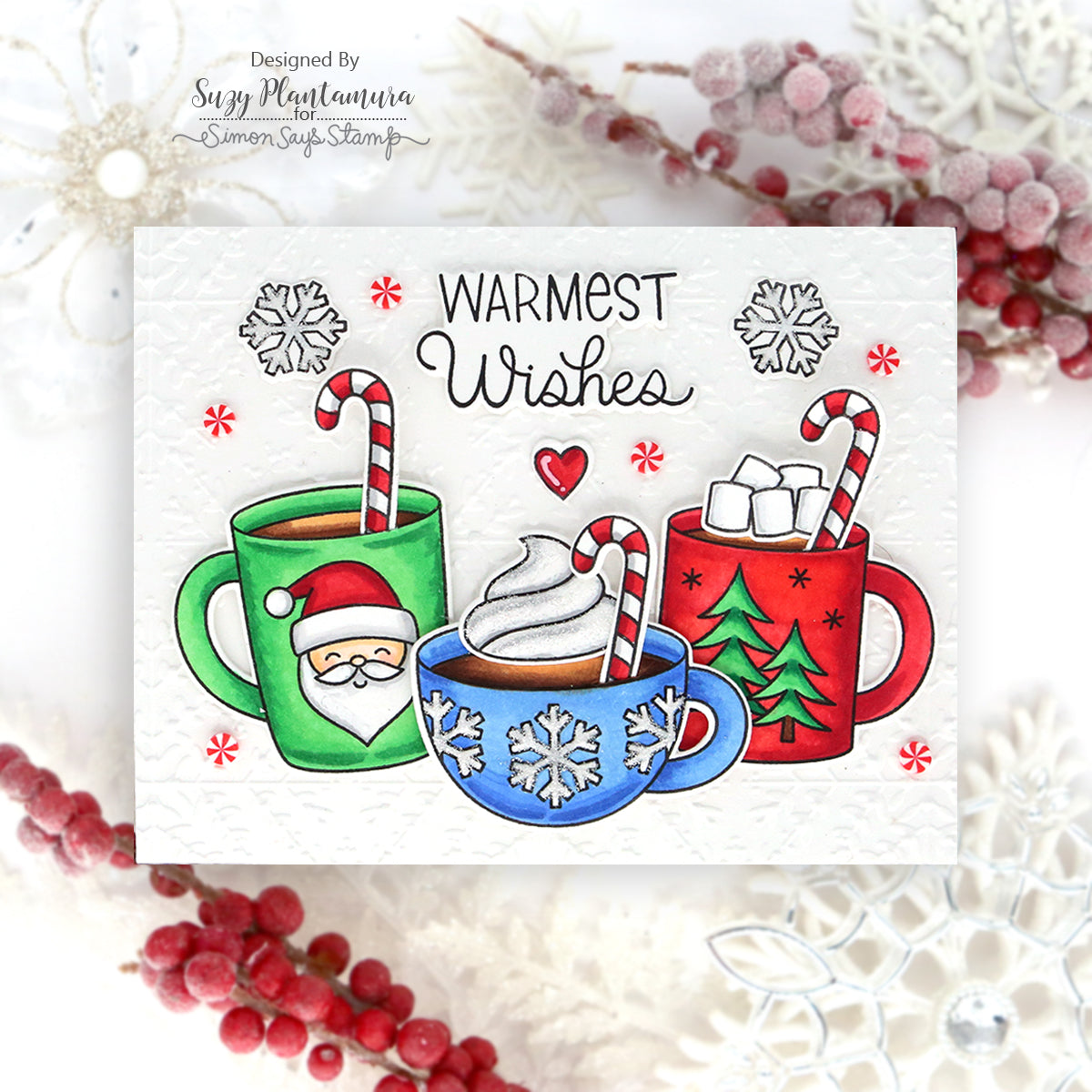 Pretty Pink Posh Warm Heart STAMPtember Exclusive Card from Suzy Plantamura with three cups of cocoa is bright green, blue and red. The sentiment warmest wishes is in the top center of the card.