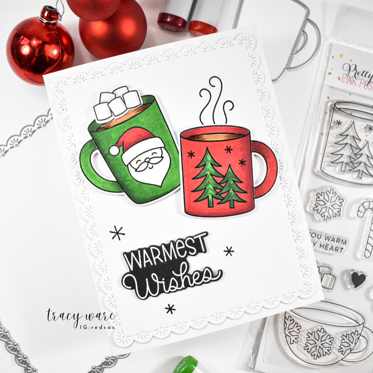 Pretty Pink Posh Warm Heart STAMPtember Exclusive Card from Tracy Ware containing the Sentiment Warmest Wishes and cups of cocoa. The green cup of cocoa has Santa Claus on the front and marshmallow on top. The red cup of cocoa has pine trees on the front with stream on top.