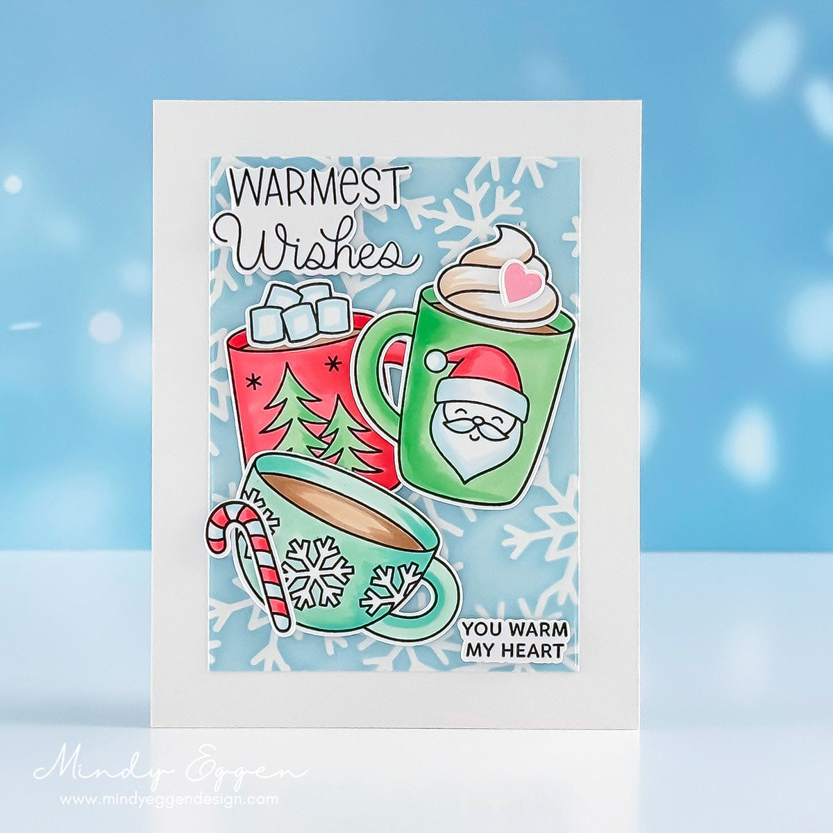 Pretty Pink Posh Warm Heart STAMPtember Exclusive Card from Mindy Eggen with three cups of cocoa is bright green, blue and red. The sentiment warmest wishes is in the top left of the card | color-code:ALT05