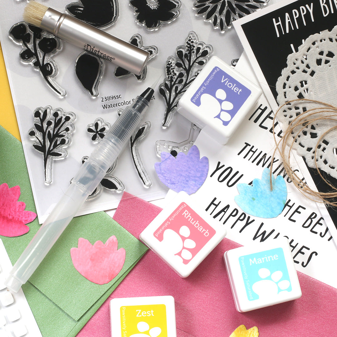 Stamping tools and ink pads on a colorful background with text and decorative elements.
