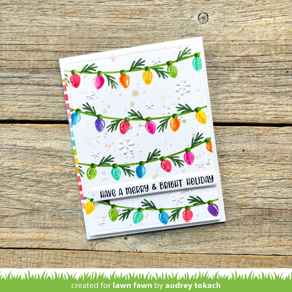 Greeting card with colorful Christmas lights design on a wooden surface