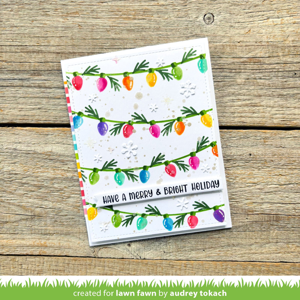 Greeting card with colorful Christmas lights design on a wooden surface
