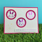 Card with bunnies and text 'wishing you joy & jellybeans' on a grassy background