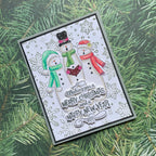 Christmas card with snowmen and festive text on a green pine branch background
